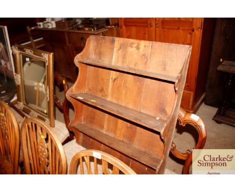 An antique stripped pine hanging shelf