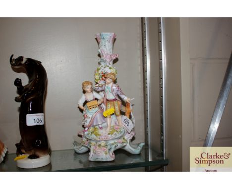 A German porcelain floral encrusted&nbsp;candlestick with figure decoration