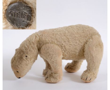 EARLY STEIFF POLAR BEAR with a jointed body and black boot button eyes. With a Steiff button in it's ear. 21cms high, 36cms l