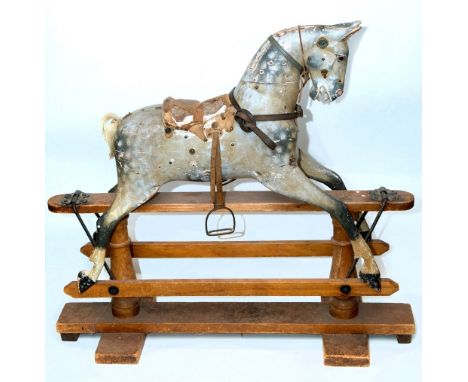 ANTIQUE ROCKING HORSE a painted pine rocking horse with saddle and stirrups, and mounted on a pine base. 96cms high