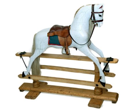 ROCKING HORSE a painted wooden rocking horse with saddle, stirrups and accessories. Mounted on a pitch pine base. 113cms high