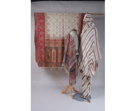 THREE EARLY C19TH SHAWLS A stripey silk shawl with tassels. (fair condition) 294" x 138". A hand woven Kashmir shawl with cen