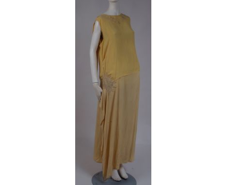 A 1920'S CREPE SILK & BEADED DRESS Soft yellow silk dress with dropped waist, glass bead and diamante star motif at the hip, 