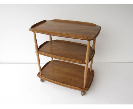A light wood Ercol three tier trolley on castors 