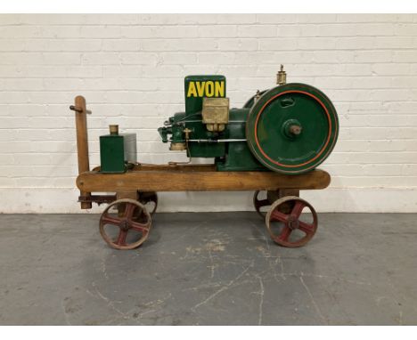 An Avon stationary enginesingle horizontal cylinder, cast water tank painted Avon in yellow, twin 15¾' solid flywheel, brass 