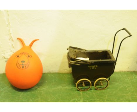 A 1970's orange coloured space hopper and a small doll's pram, painted in brown and raised on a metal base, measuring 54cm x 