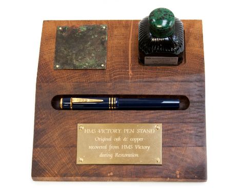 H.M.S. Victory pen stand comprising a piece of H.M.S. Victory oak, a unique Onoto pen featuring a gilded silver button as Nel