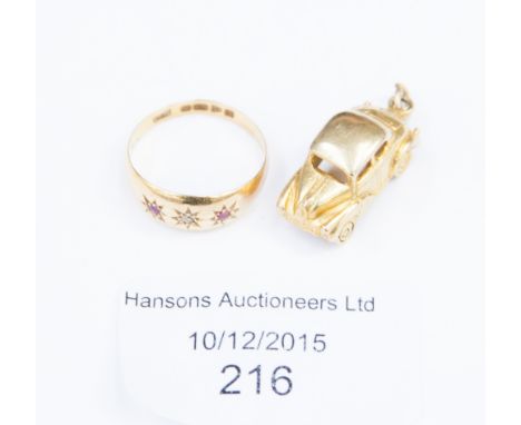 An 18ct gold, ruby and diamond ring, two rubies, central diamond set in star cuttings; together with a 9ct gold 'Rover' car c