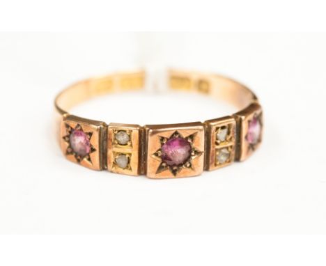 An Edwardian 15ct gold ruby and diamond ring, three matched pale rubies with two diamonds each, side of the central stone, in