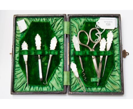 A Victorian leather cased green velvet lined sewing/manicure set containing two embroidery stilettos, scent bottle corkscrew,