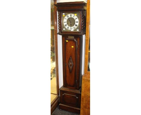 A George V oak eight day longcase clock, having a silvered chapter dial, with black Roman numerals. Plaque dating it 1931.