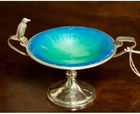 A silver enamelled pedestal twin handled trinket dish, having engine turned enamelling and a penguin sitting on a handle  