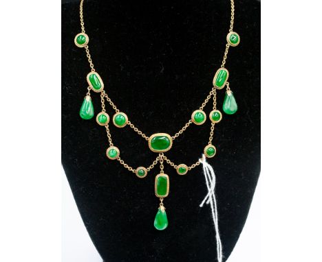 A yellow metal and jade pendant necklace, having oval and circular links, set green jade in rub over setting, with three pend