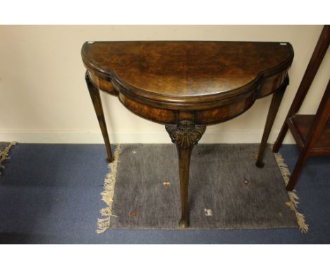 An early Twentieth Century walnut demi-lune card table, raised on cabriole legs