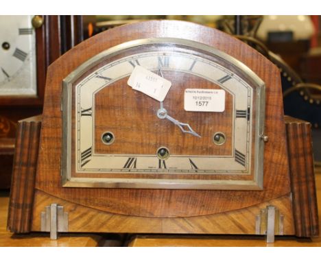 An Art Deco veneered mantle clock, having a partialy silvered dial with Roman numerals. key & pendulum.