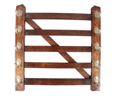 AN EDWARDIAN MAHOGANY WHIP RACKin the form of a five-bar gate, with brass hooks for five riding crops on each side, 25cm x 46