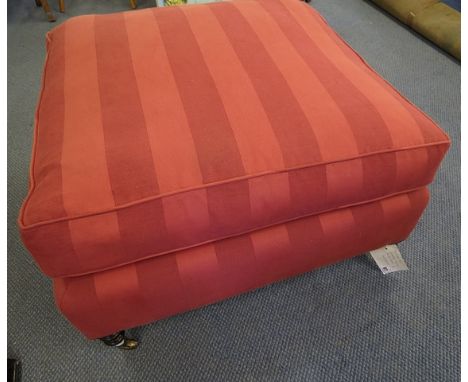 A large striped red upholstered pouffe standing on turned mahogany legs and castors, supplied by George Smith of Chelsea in 1