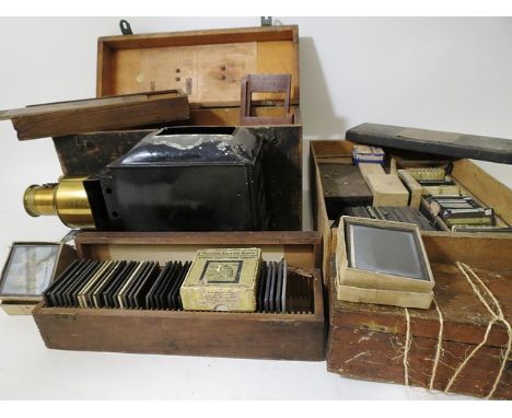 An early 20th century magic lantern with brass lens and wooden box, interior of lid with factory label for Walter Tyler's Hel