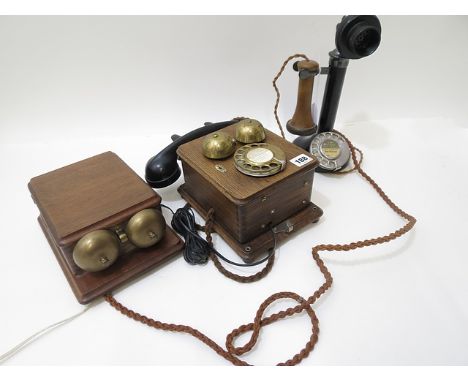 A Bell telephone wall hanging phone, oak cased with black Bakelite handset, along with a vintage black candlestick telephone 