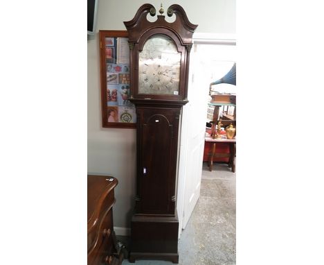 A George III  mahogany long case clock, the moulded scroll pediment applied with brass bosses, flanking a half reeded brass f