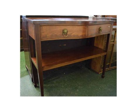 George III mahogany serpentine fronted two-drawer side table with open shelf on tapering square spade feet, fitted with lion 