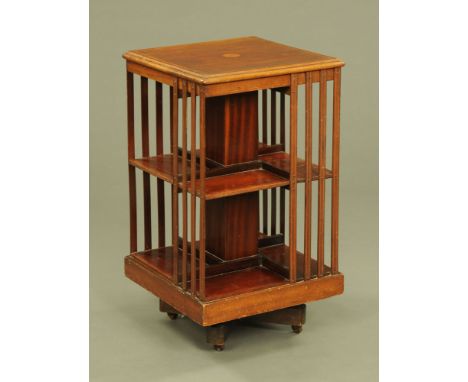 An Edwardian inlaid mahogany square revolving bookcase, with slat supports and raised on ceramic castors.  Height 81 cm, widt