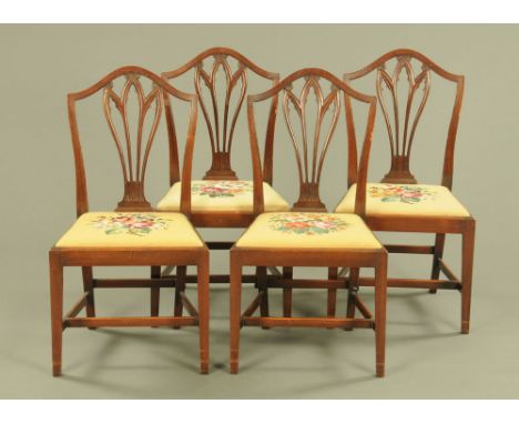 A set of four George III mahogany dining chairs, with arched top rails, pierced splat back and drop in seats upholstered in w