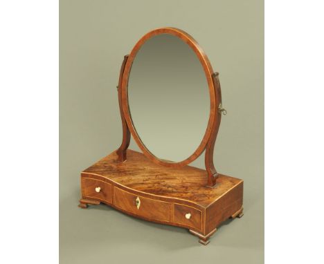 A 19th century mahogany dressing table mirror, oval with serpentine base fitted with three drawers and raised on bracket feet