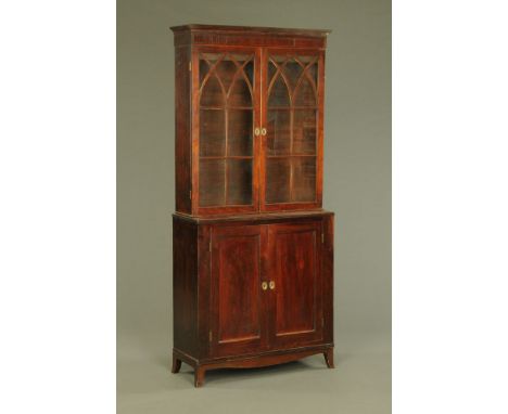 A George III mahogany bookcase, the upper part enclosed by a pair of astragal glazed lancette pattern doors, base enclosed by