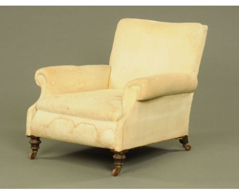 A Victorian Howard style stuffover armchair, raised on turned front legs with brass and ceramic castors.  Height to top of ba