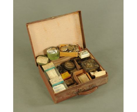 A small leather case containing a quantity of clock and watch parts.