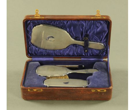 A cased silver dressing table set, comprising mirror, comb and two brushes, Birmingham Hallmark 1928.