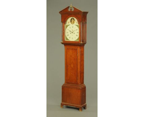 An early 19th century mahogany longcase clock, with broken arch pediment above the arched painted dial with Roman numerals, t