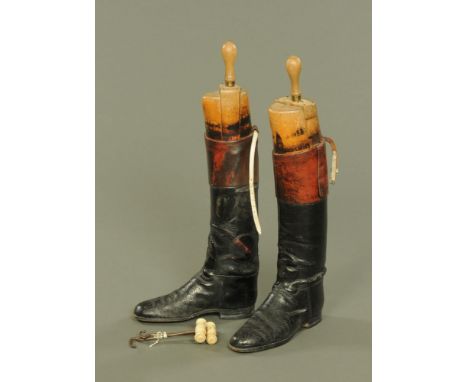 A pair of vintage leather riding boots, with wooden trees and with boot pulls.