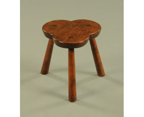 A yew wood trefoil stool, well figured with three angled supports.  Height 30 cm, width 28 cm. CONDITION REPORT: The stool is