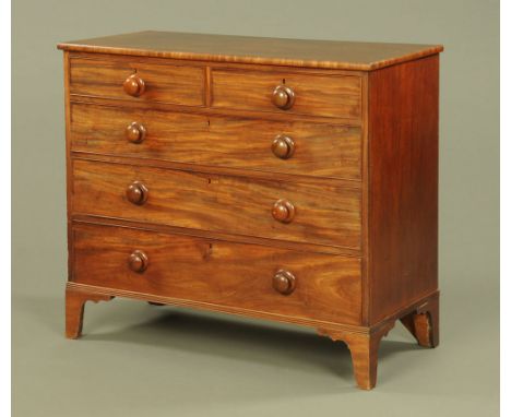 An early Victorian mahogany chest of drawers, two short and three long with wooden knob handles and cockbeading to each drawe