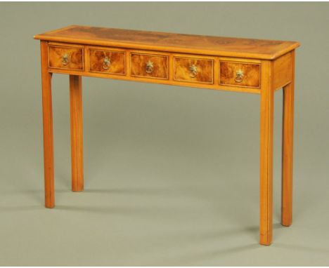 A walnut five drawer hall table, with crossbanded moulded edge and fitted with five frieze drawers with brass drop handles an