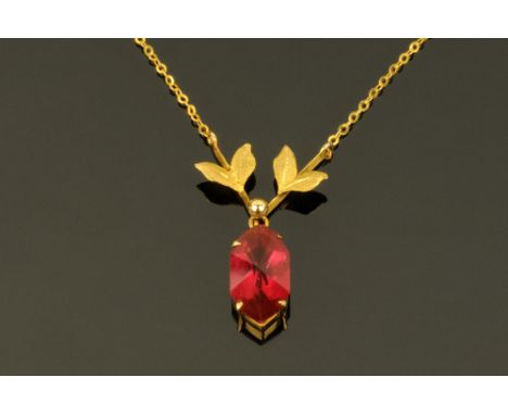 A 9 ct gold leaf shaped pendant and chain, with ruby coloured stone. CONDITION REPORT: The chain length is 40 cm.  The red st