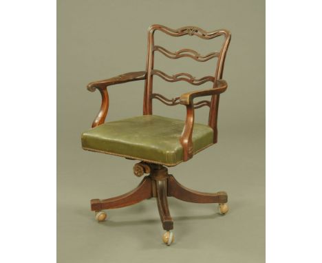 A mahogany Hepplewhite style revolving desk chair, ladder back with leather seat and raised on four legs terminating in Sheph