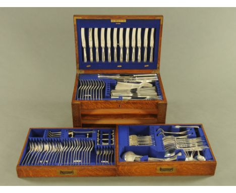 An oak canteen containing a quantity of silver plated cutlery, comprising 12 table knives and forks, 12 fish knives and forks