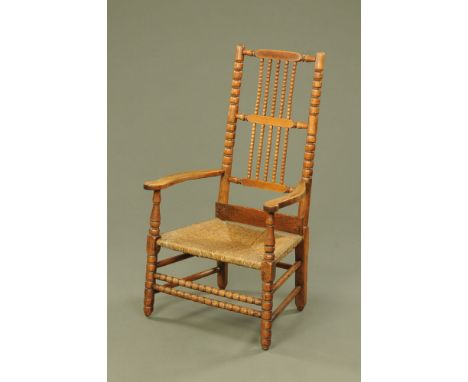 A 19th century bobbin turned rush seated armchair.  Height to top of back 110 cm, width across arms 62 cm.