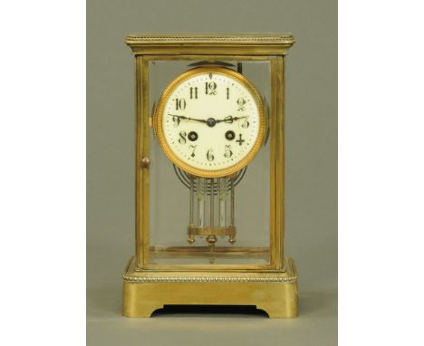 A late Victorian brass four glass library clock, with two train striking movement with Arabic numerals and mercury weighted p