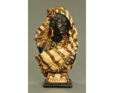 A Moroccan ware bust, a female figure wearing a head scarf, cream, brown and black painted with gilding.  Height 64 cm, width