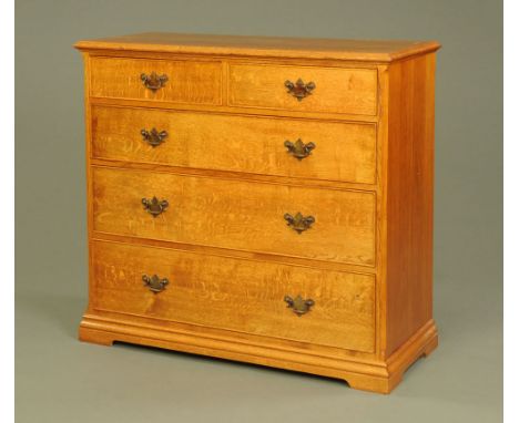 An oak chest of drawers, in the Georgian style with two short and three long graduated drawers with brass drop handles and sh