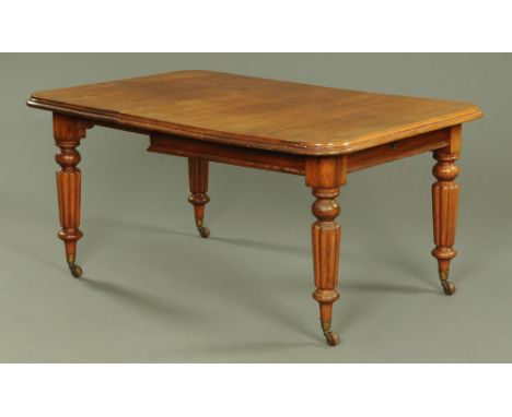 A Victorian mahogany extending dining table, rectangular, with rounded corners, moulded edge and raised on tapered reeded leg