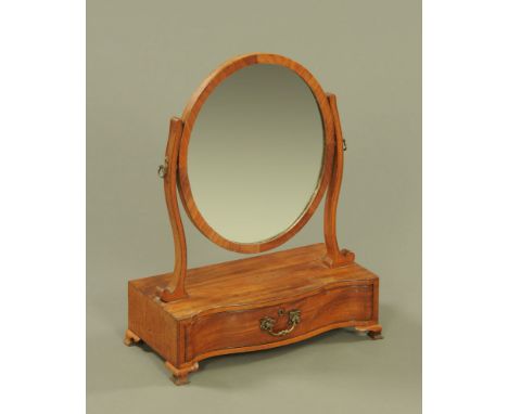 A 19th century mahogany toilet mirror, with oval frame and serpentine base fitted with a single drawer raised on ogee bracket