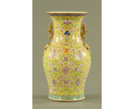 A 19th century Cantonese yellow ground vase, elaborately decorated with foliate designs and with gilt handles.  Height 35.5 c