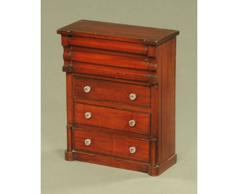 A Victorian miniature Scotch chest of drawers, with glass knob handles and raised on a plinth base.  Height 54 cm, width 43 c