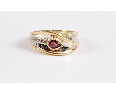 An 18ct ruby and white hardstone ring, the pear shaped ruby, collet mounted within a tapering crossover panel of white gold s