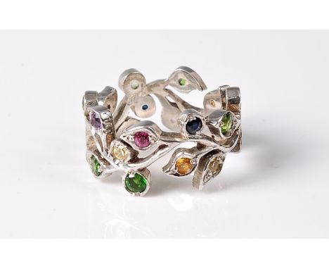 A silver and multi gemset floral sprig eternity ring, the undulating sprig with leaves set with mixed gem stones to include s